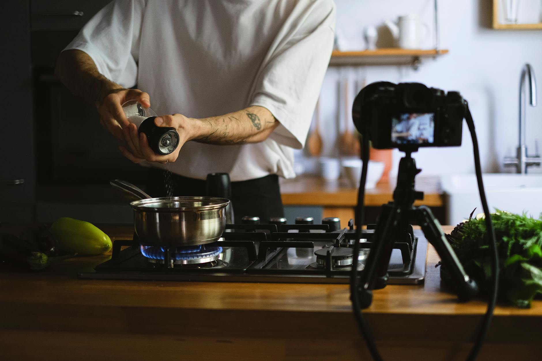 vlogger recording himself cooking in a kitchen